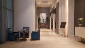 a hallway with blue chairs and a table in a building at Khalil's Horizons 101 Studio Type Condominium in Cebu City