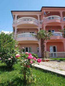 a pink house with flowers in front of it at Apartments Ban in Novi Vinodolski