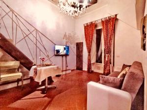 a living room with a couch and a tv and stairs at Florentine Style Central Apartments in Florence