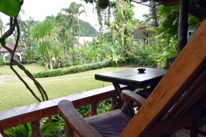 
a wooden bench sitting on top of a lush green lawn at Homestay Chiangrai in Chiang Rai
