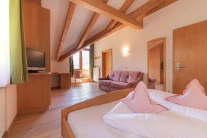 Zimmer mit einem Bett, einem Sofa und einem TV in der Unterkunft Hotel Alpenfrieden in Weißenbach