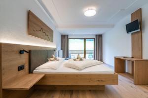 A bed or beds in a room at Hotel Alpenfrieden