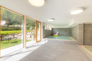 een zwembad in een huis met grote ramen bij Hotel Alpenfrieden in Rio Bianco