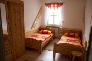 2 Betten in einem kleinen Zimmer mit Fenster in der Unterkunft Ferienwohnung Heidrun Bemetz in Unterreitnau