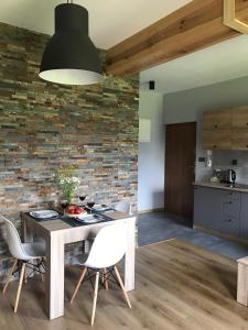 a kitchen and dining room with a table and chairs at ApartamentyPodZakopanem.PL in Murzasichle