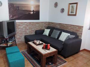 een woonkamer met een bank en een salontafel bij O Cruceiro in Lires