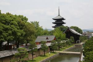 京都的住宿－京都班尼斯特酒店，一座宝塔和一座有河流和树木的建筑