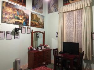 een kamer met een bureau en een tafel met een spiegel bij Albany Foreshore Guest House in Albany