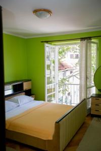 a green bedroom with a bed and a window at Apartment City Heart in Trebinje