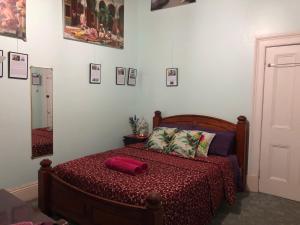 a bedroom with a bed, desk, and a painting on the wall at Albany Foreshore Guest House in Albany