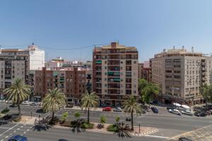 バレンシアにあるTravel Habitat Jardines de Viverosの高い建物とヤシの木が茂る駐車場がある街