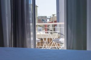 a bedroom with a view of a balcony with a table and chairs at City Center Studios in Kavála