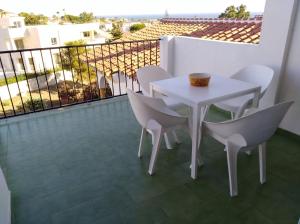ミハス・コスタにあるApartamento El Faro de Mijasの白いテーブルと椅子付きのバルコニー
