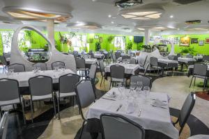 サンタ・クルス・デ・ムデーラにあるHotel Restaurante Santa Cruzの緑の壁のダイニングルーム(白いテーブル、椅子付)