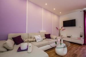 Una sala de estar con un sofá y un televisor. en Lavender & Mint, en Kaštela