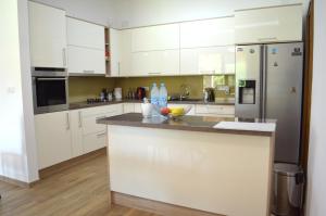 a kitchen with white cabinets and stainless steel appliances at Amal Grand Villa in Bihać
