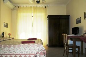 a bedroom with a bed and a desk and a window at Ianus Guest House in Rome