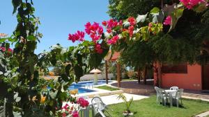 einen Garten mit rosa Blumen und einem Pool in der Unterkunft Pousada Paradise in Canoa Quebrada