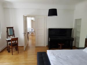 ein Schlafzimmer mit einem Bett, einem Schreibtisch und einem Klavier in der Unterkunft SIPPO Apartments in Ljubljana
