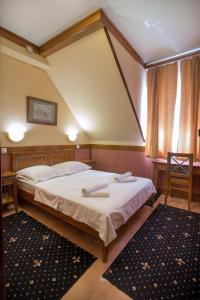 Un pat sau paturi într-o cameră la Garni Hotel Zenit
