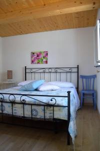a bedroom with a bed and a blue chair at Casa le Gebbie in Marzamemi +51 photos