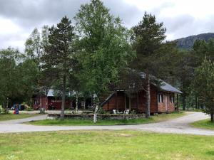 a log cabin in the woods next to a road at Tommerneset Camping in Innhavet