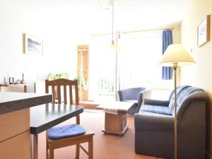 ein Wohnzimmer mit einem Sofa, einem Stuhl und einem Tisch in der Unterkunft Simplistic Apartment in Rerik Germany with Garden in Rerik