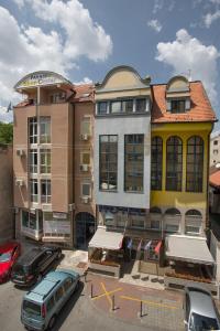 a group of buildings with cars parked in a parking lot at Garni Hotel Zenit in Novi Sad