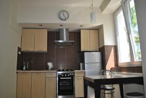 a kitchen with wooden cabinets and a clock on the wall at Apartament Gorczewska Przy Metrze in Warsaw