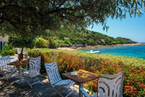 a table and chairs with a view of the ocean at Hotel Le Maquis in Porticcio