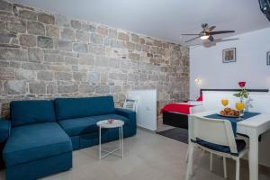 a living room with a blue couch and a brick wall at VD 1892 in Split
