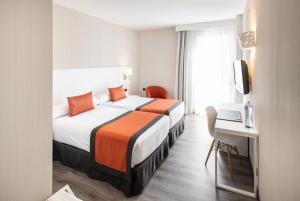 a hotel room with a large bed and a desk at Catalonia Bristol in Sant Andreu de la Barca