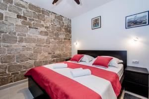 two beds in a room with a stone wall at VD 1892 in Split