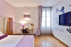 Pokój hotelowy z łóżkiem, biurkiem i telewizorem w obiekcie Solo Experience Hotel we Florencji
