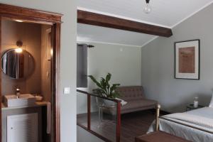 um quarto com uma cama, uma cadeira e um espelho em Villa Várzea Hiker Nest na Várzea