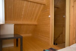 Jest to drewniany pokój z drewnianą podłogą i biurkiem. w obiekcie Domki Pod Sosnami w Rowach