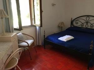 タオルミーナにあるVilla Marieddaのベッドルーム(青いベッド1台、椅子付)