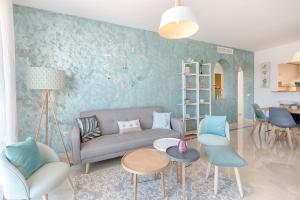 uma sala de estar com um sofá, cadeiras e uma mesa em Sea & mountain view penthouse em Estepona
