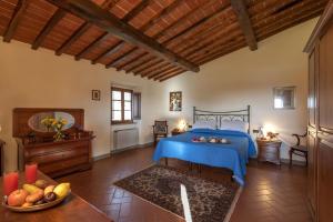 Un dormitorio con una cama azul y un bol de fruta en Savernano, en Reggello