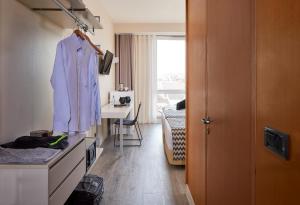 a hotel room with a robe hanging on the wall at Occidental Faro in Faro