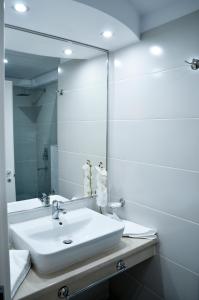a bathroom with a white sink and a mirror at Hotel Afrodita -Valenii De Munte in Vălenii de Munte