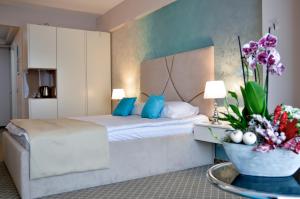 a hotel room with a bed and a table with flowers at Hotel Afrodita -Valenii De Munte in Vălenii de Munte