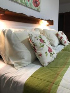 Una cama con sábanas blancas y almohadas. en Hotel Bergblick en Pomerode