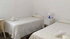 ネルハにあるApartamento Toboso Lenaのベッド2台、ランプ1台が備わる客室です。