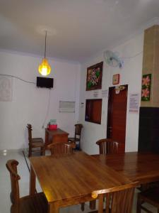 a dining room with a wooden table and chairs at Dwiki Putra Home Stay in Nusa Lembongan