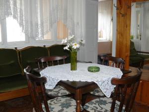 a dining room table with a vase of flowers on it at Őrségi Gorza Vendégház in Nagyrákos