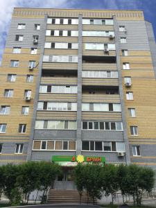 チュメニにあるСчастливая квартира на Самарцеваの階段を前に建つ高層ビル