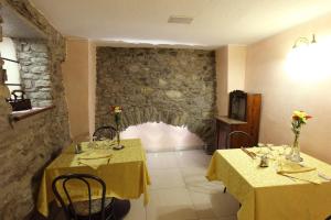 two tables in a restaurant with yellow table cloth at Hotel Cecchin in Aosta