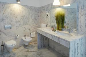 a bathroom with a sink and a toilet at Occidental Faro in Faro