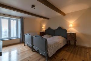 a bedroom with a bed and a large window at Les Trois Voisins in Bourseigne-Vieille